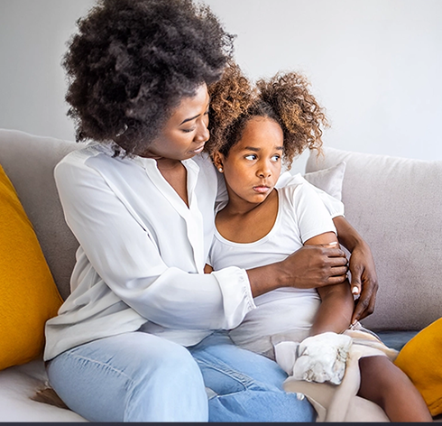 Mère et enfant assis étroitement l’un contre l’autre dans un salon lumineux, reflétant l’impact émotionnel d’un diagnostic de TNBC au Canada.